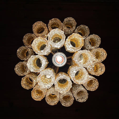 Decorative ceiling light fixture with glass shades on a black background